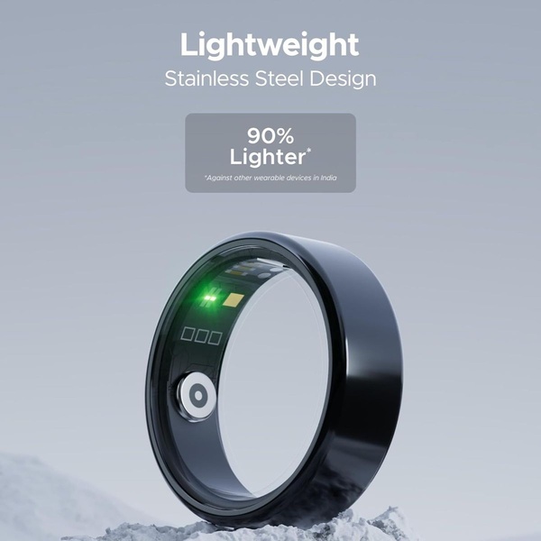 A high-fidelity product shot of a black smart ring resting on a snowy surface, emphasizing its lightweight stainless steel construction.